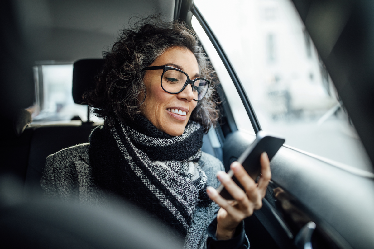 Woman in car looking at phone