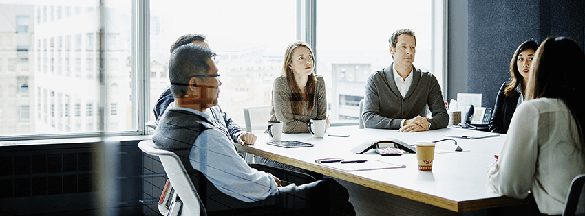 Group of people sat down having a discussion in a meeting room