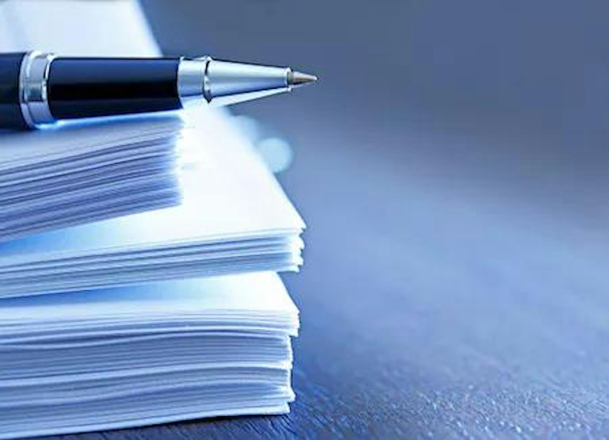 Image of a pen a stack of documents signifying the importance of keeping entity documents in a unified system.