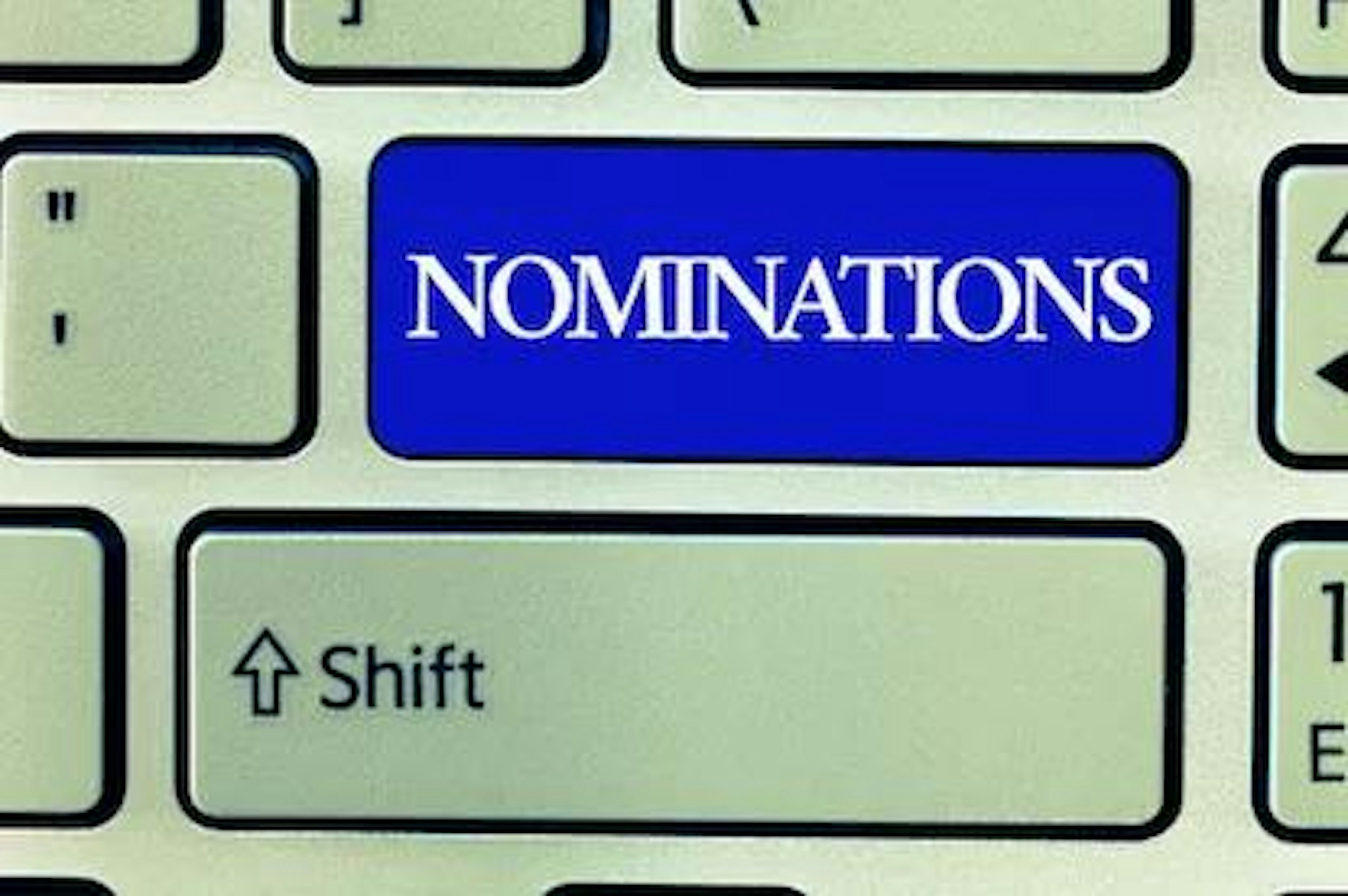 A 'nominations' button on a keyboard signifying a sample nominating committee charter.