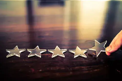 Image of person placing 5 stars on the table representing ratings