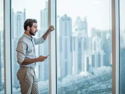 Board member looks out office window onto cityscape considering how to master governance in the context of ESG