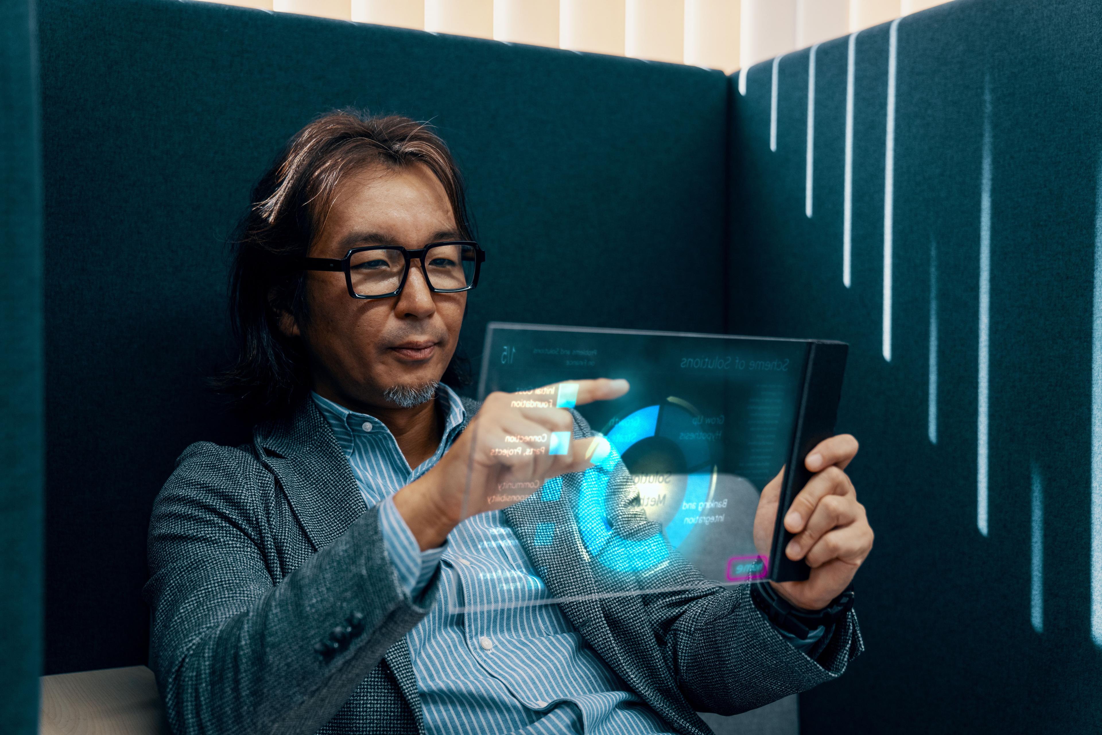 Mid adult businessman using futuristic AI tablet computer