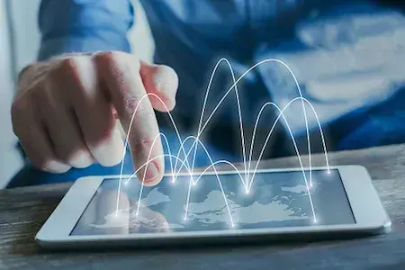 Futuristic illustration of tablet displaying a map of the world and a person selecting various locations representing global subsidiary management