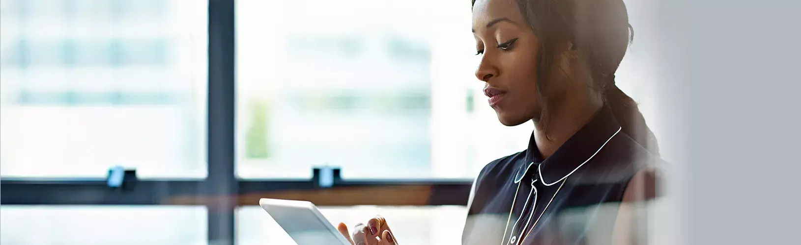 A CISO reviewing the business case for cyber risk management on a tablet.