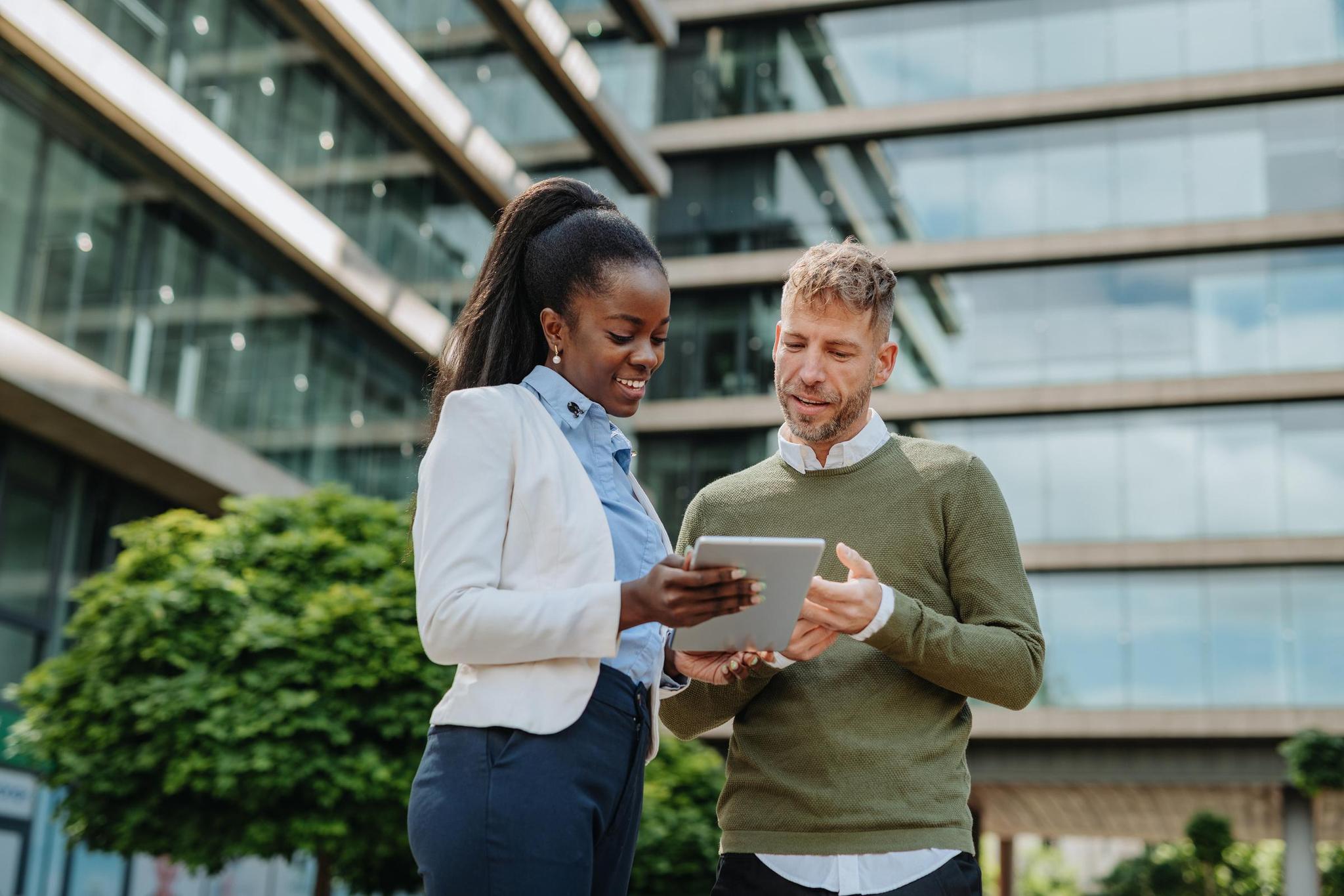 Professionals collaborate on a due diligence questionnaire through their tablet outside the office.