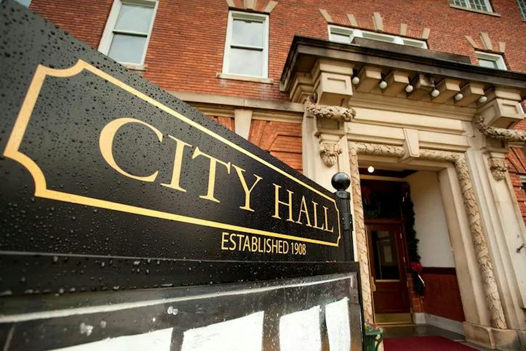 Building with sign outside reading "City hall, established 1908"