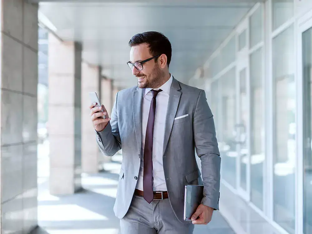 Professional carrying CSR book and reading an article on his phone.