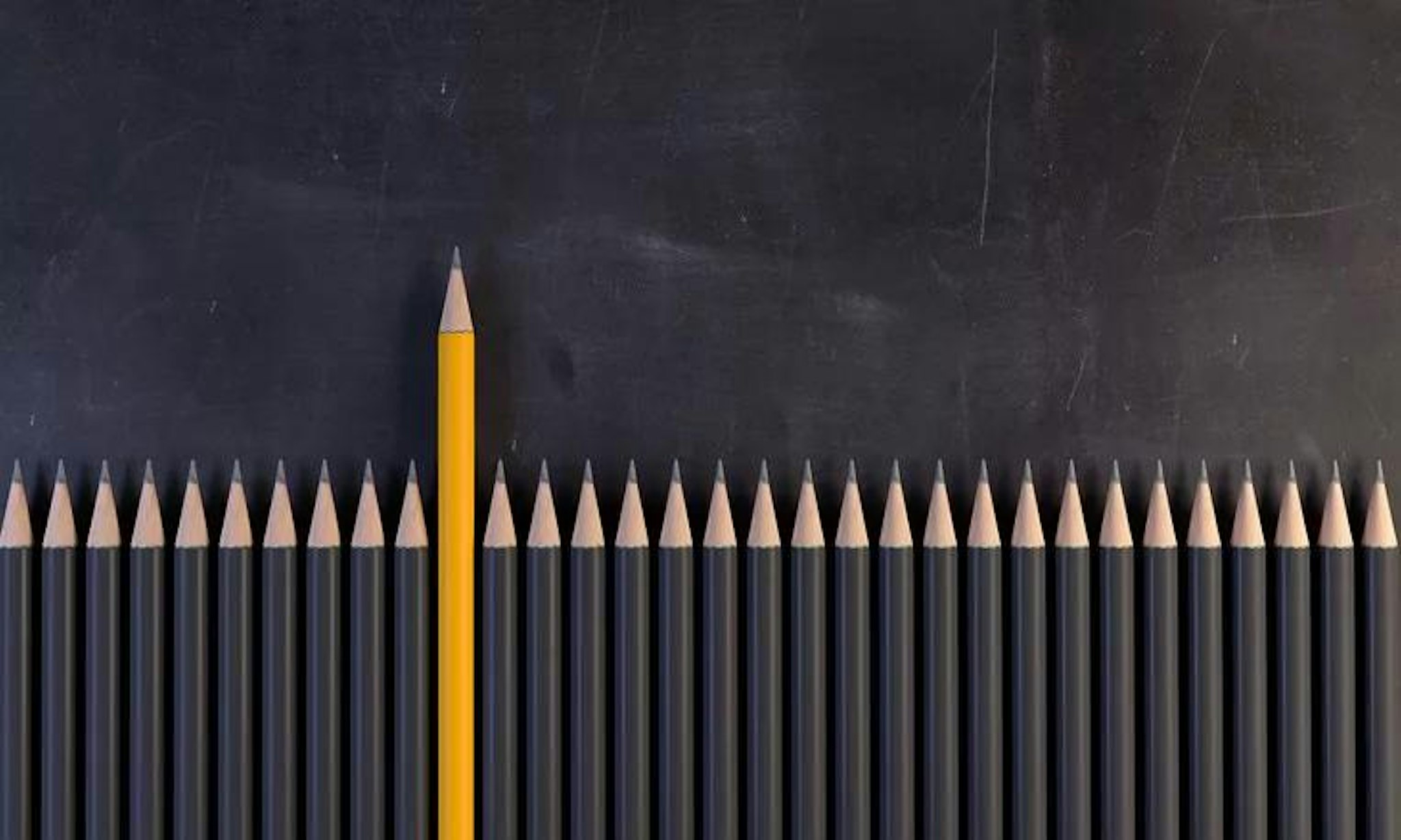 School pencils lined up with one yellow pencil. Image represents student success.