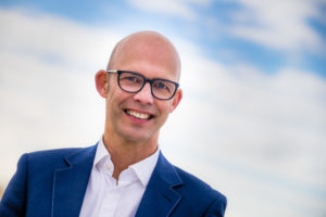 Foto van een man in een pak met een bril