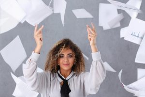 Papierloos vergaderen: een vrouw gooit een stapel papier weg